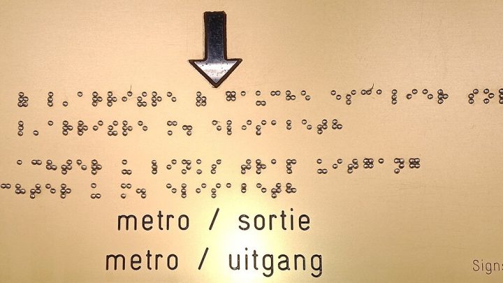 Braille text on a sign next to printed lettering