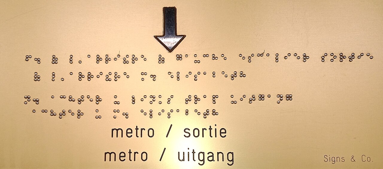 Braille text on a sign next to printed lettering