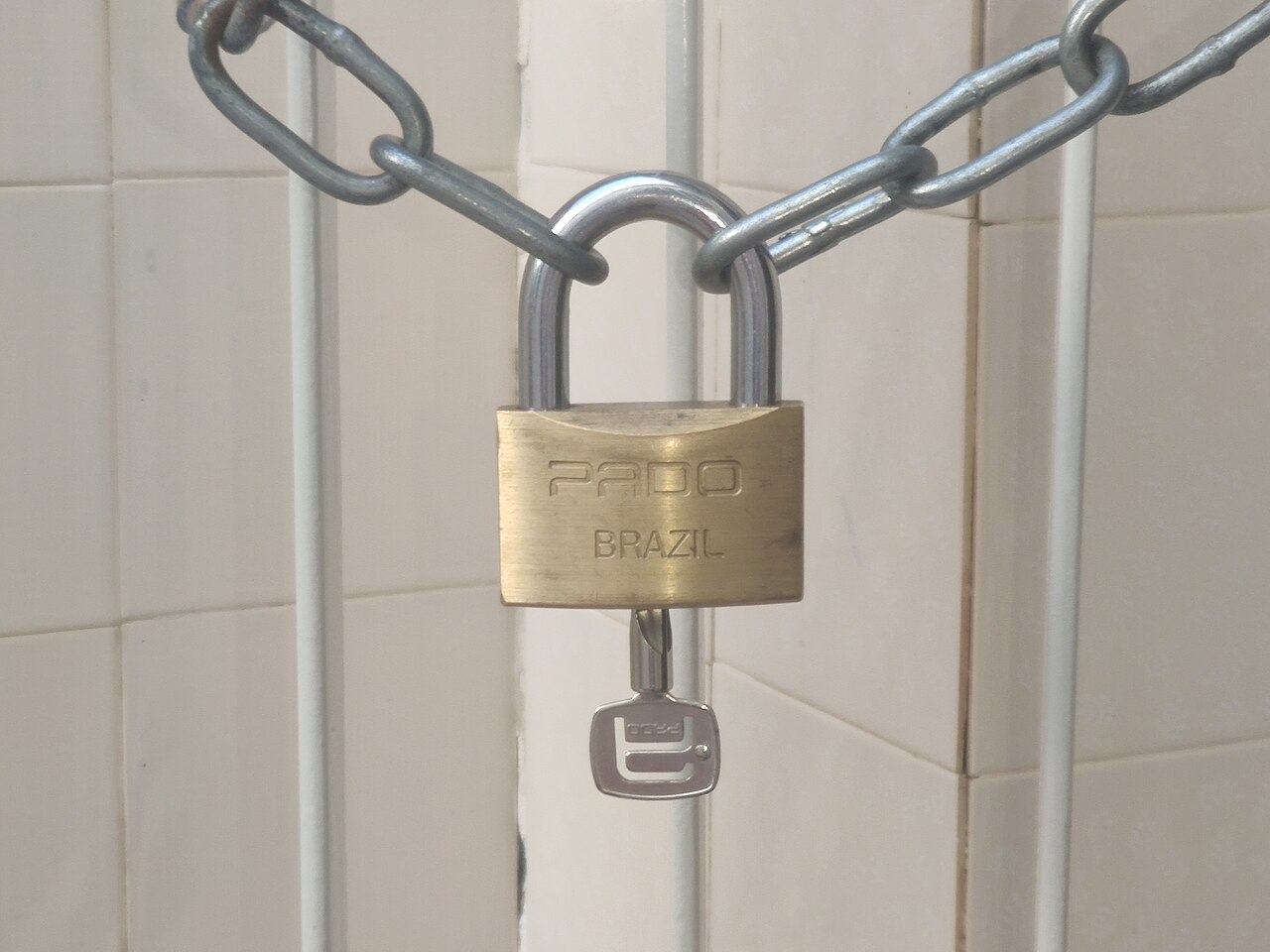 Brass padlock securing a metal chain